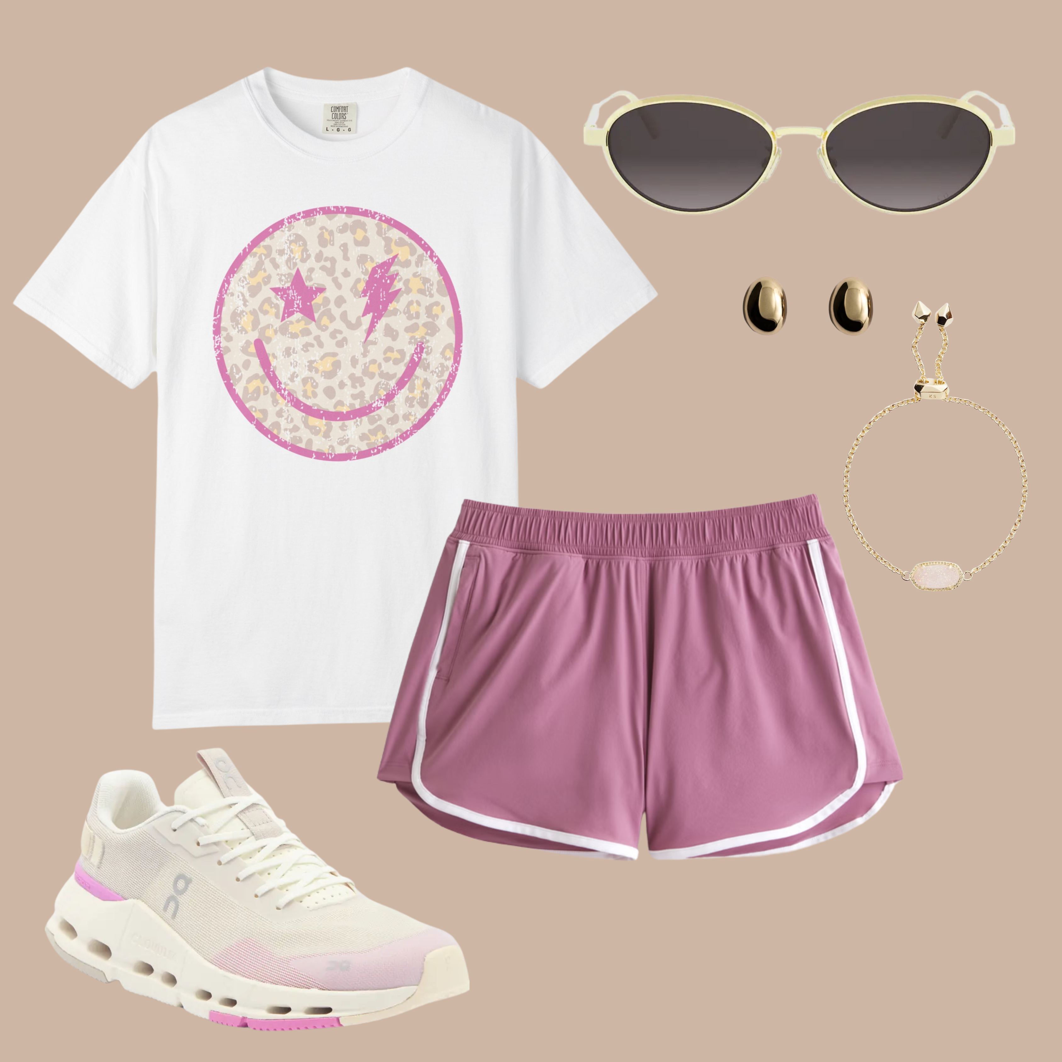 White Comfort Colors t-shirt with a distressed pink leopard print smiley face and lightning eyes, styled with mauve athletic shorts and casual sneakers.