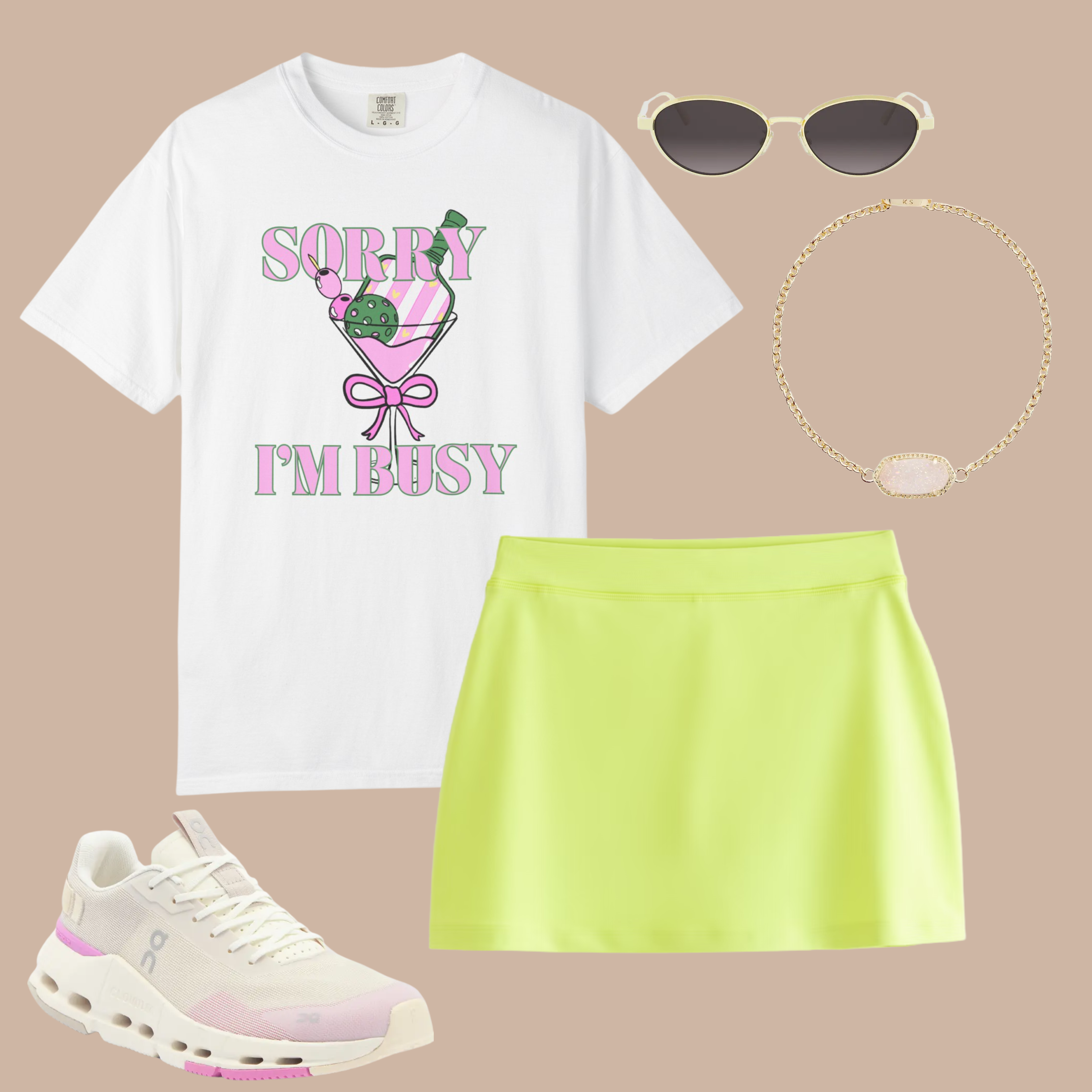 White Comfort Colors t-shirt with “Sorry I’m Busy” pink cocktail glass graphic, styled with neon yellow skort, sneakers, gold bracelet, and retro sunglasses.