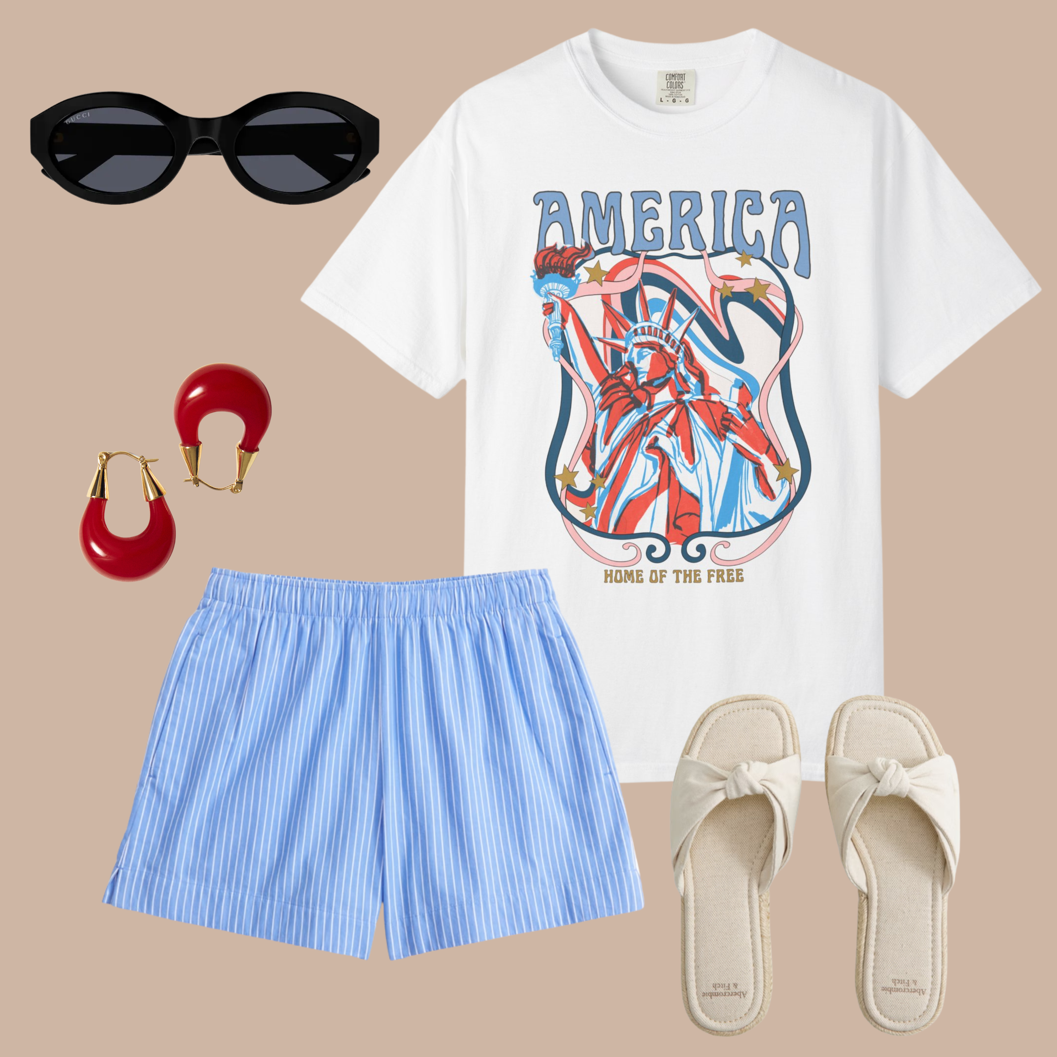 White tee with retro-style Statue of Liberty art and “America Home of the Free” text, styled with blue striped shorts, cream slides, and red earrings.